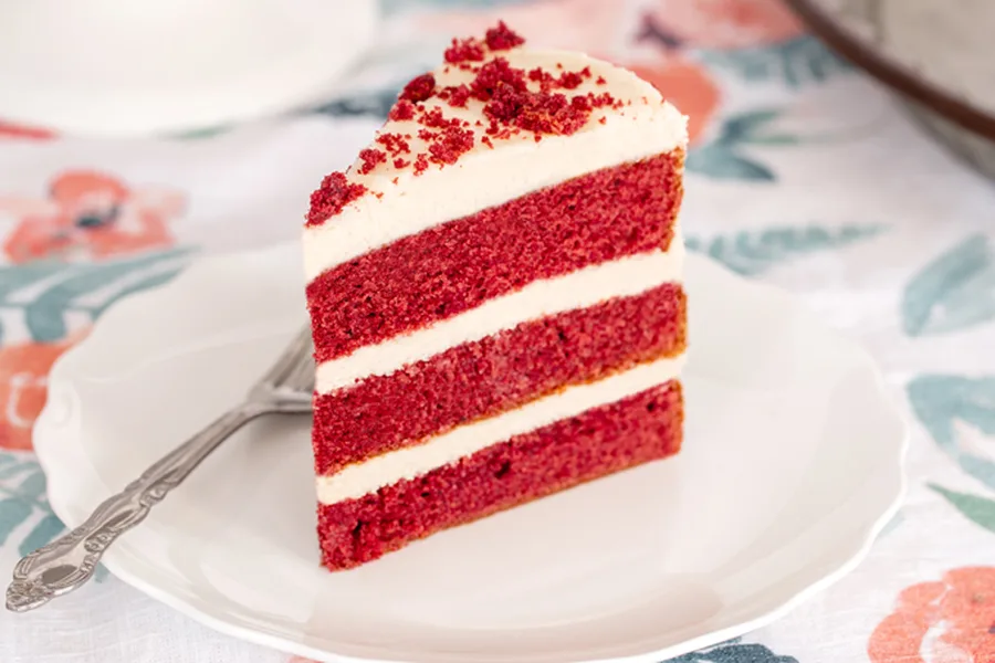 Slice of red velvet cake with cream cheese frosting
